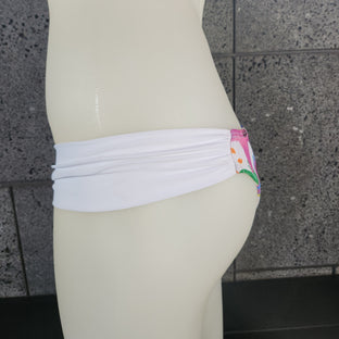 This image features the Loco Boutique Aloha Friday Bandeau Bikini Top, part of a stylish swimwear set. The bandeau top displays a vibrant tropical bloom print with a mix of green leaves, orange blooms, and blue accents, creating a fresh and colorful look.