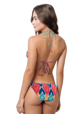 Woman wearing a colorful bikini set with batik prints on a white background