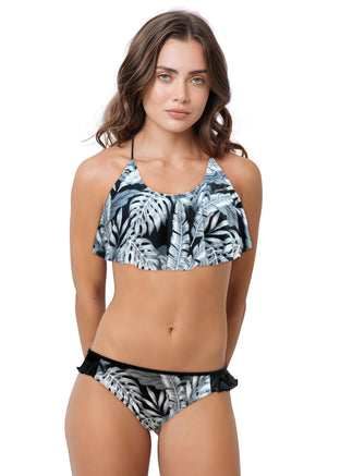 Woman wearing a tropical leaf patterned bikini on a white background