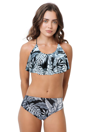 Woman wearing a tropical leaf patterned bikini on a white background