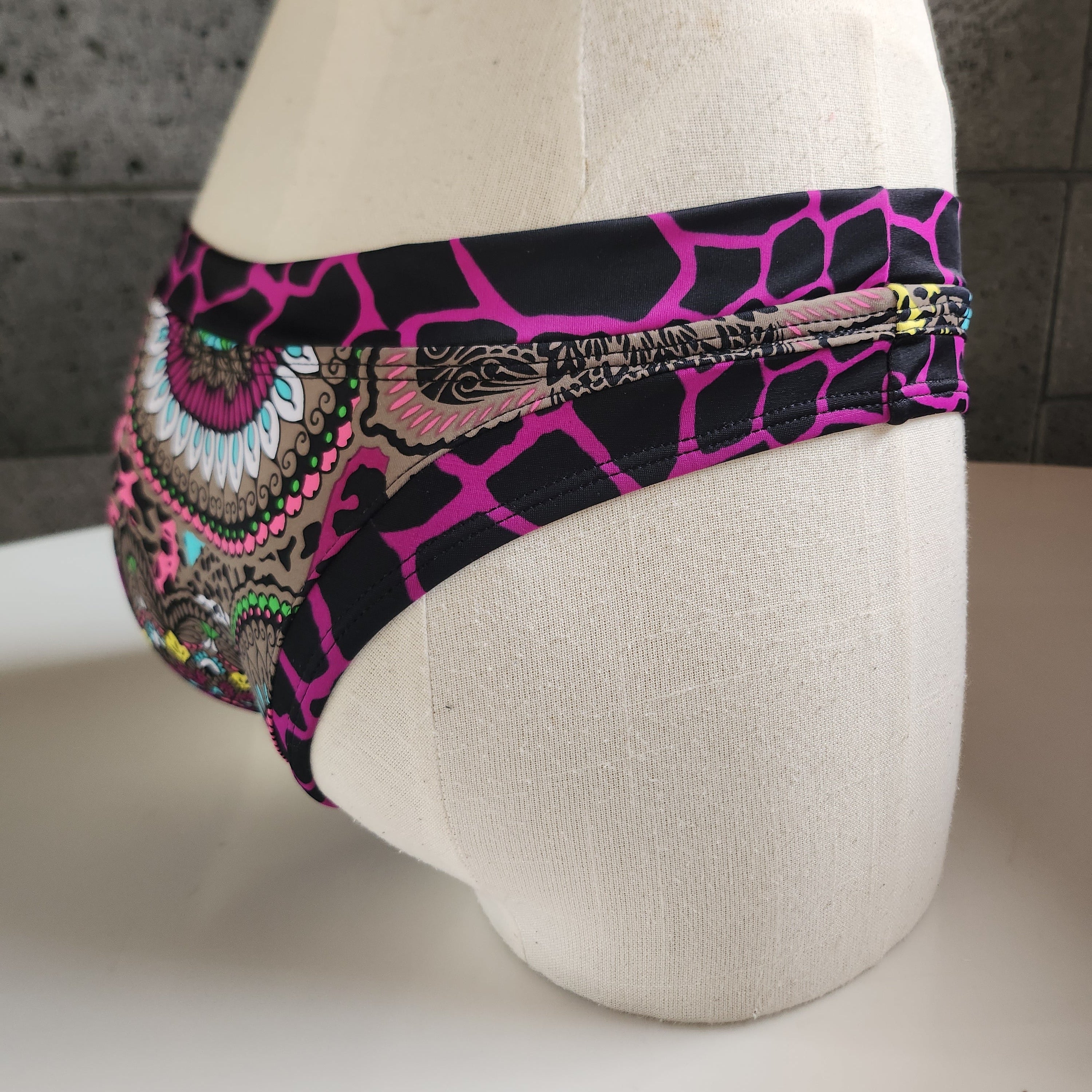 Colorful patterned bikini bottom on a mannequin with a white background