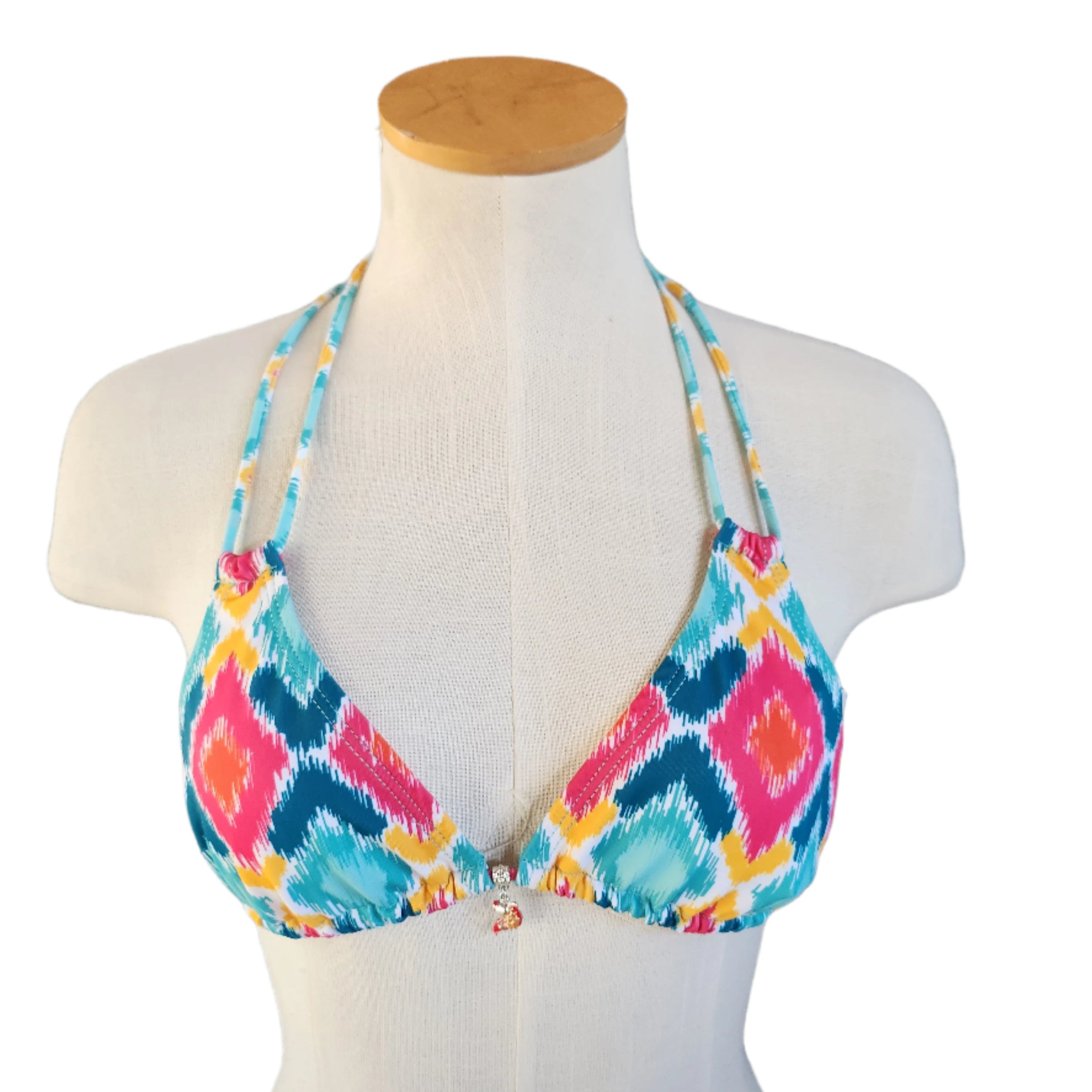 Colorful patterned bikini top on a mannequin with a white background.