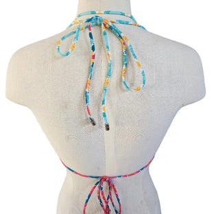 Colorful patterned bikini top on a mannequin with a white background.