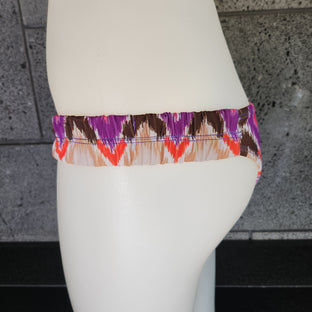 Colorful bikini bottom on a mannequin against a dark background