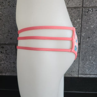 Colorful bikini bottom with geometric pattern on a mannequin against a gray background