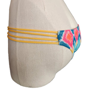 Colorful strappy bikini bottom on a mannequin with a white background