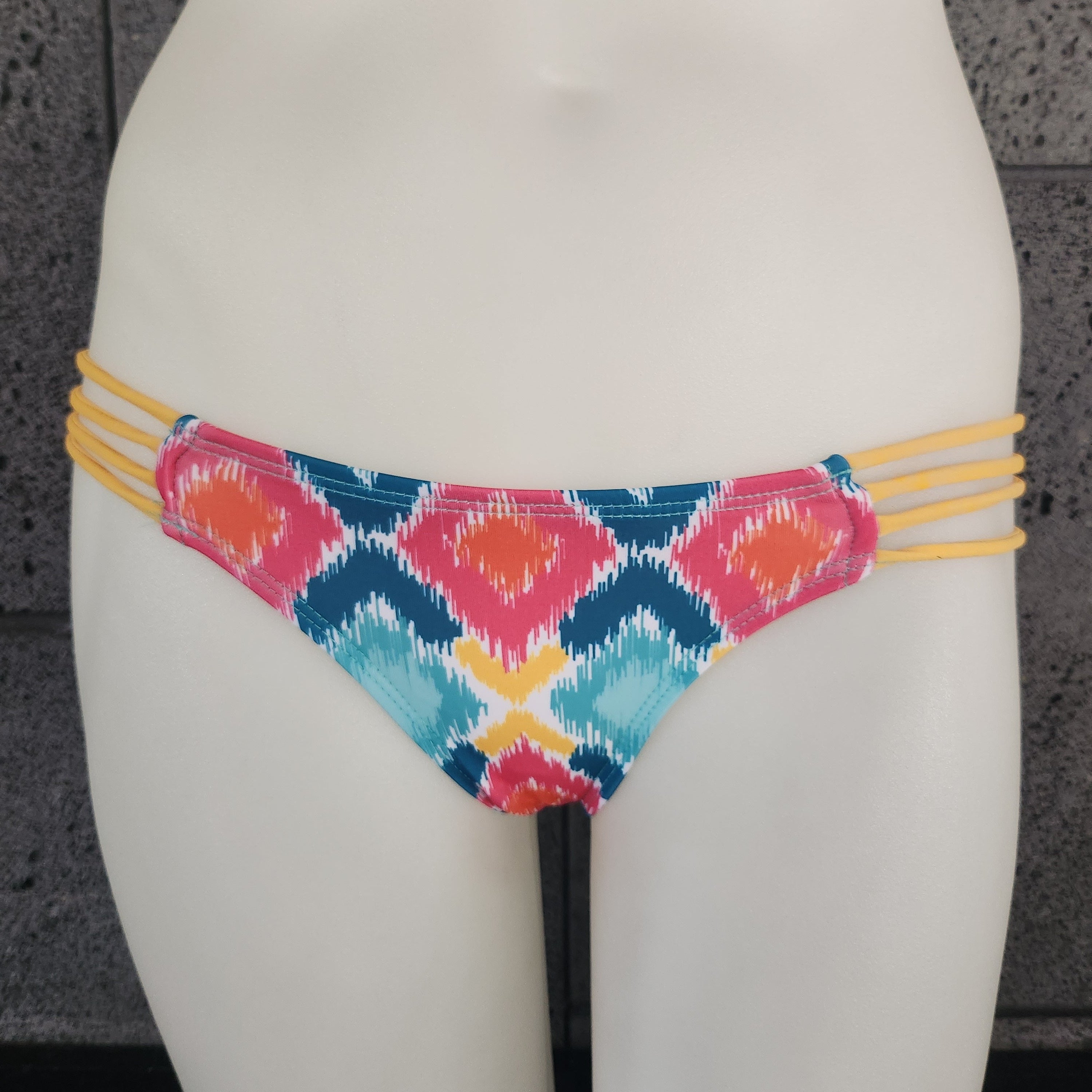 Colorful bikini bottom with geometric pattern on a plain background