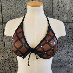 Mannequin wearing a brown bikini top on a textured gray background