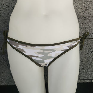 Camouflage-patterned bikini bottom on a mannequin against a gray concrete wall.