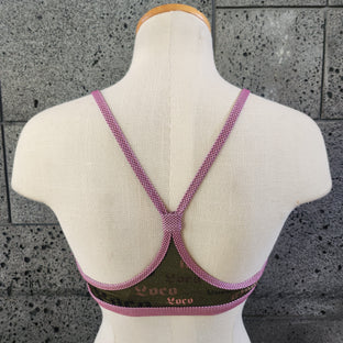 Triangle bikini top on a mannequin bust against a gray concrete background