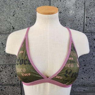 Triangle bikini top on a mannequin bust against a gray concrete background
