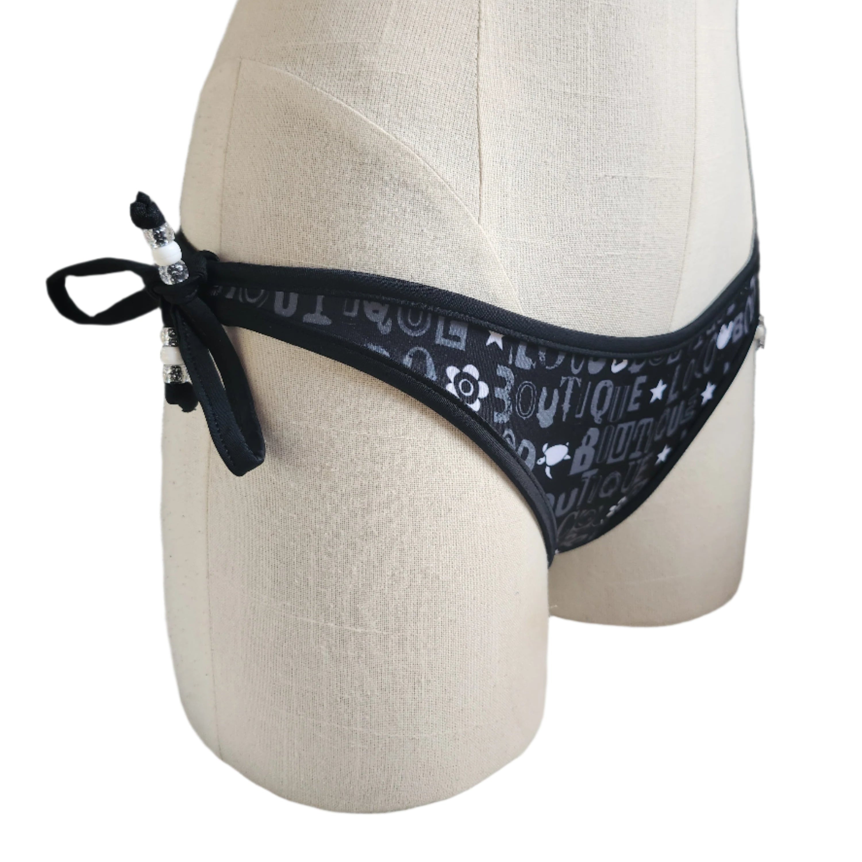 Black bikini bottom with 'Loco Boutique' text on a mannequin against a white background