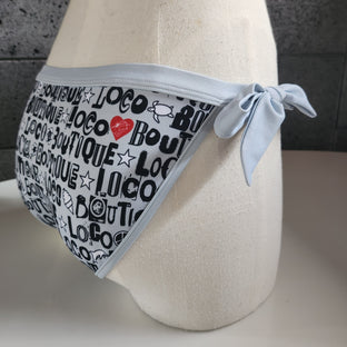 Gray bikini bottom with black text pattern on a mannequin with a neutral background.
