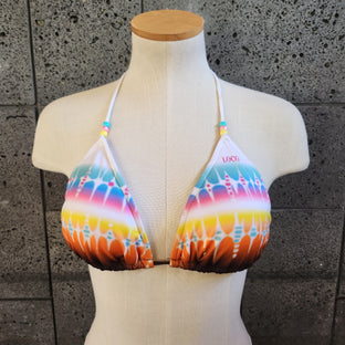 Colorful bikini on a mannequin against a concrete wall.