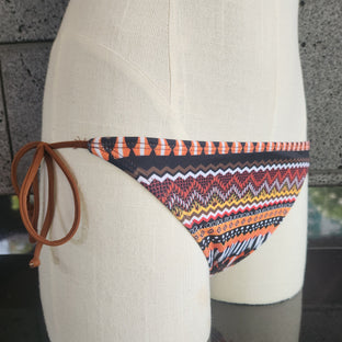 Decorative bikini bottom with a colorful pattern on a mannequin against a neutral background