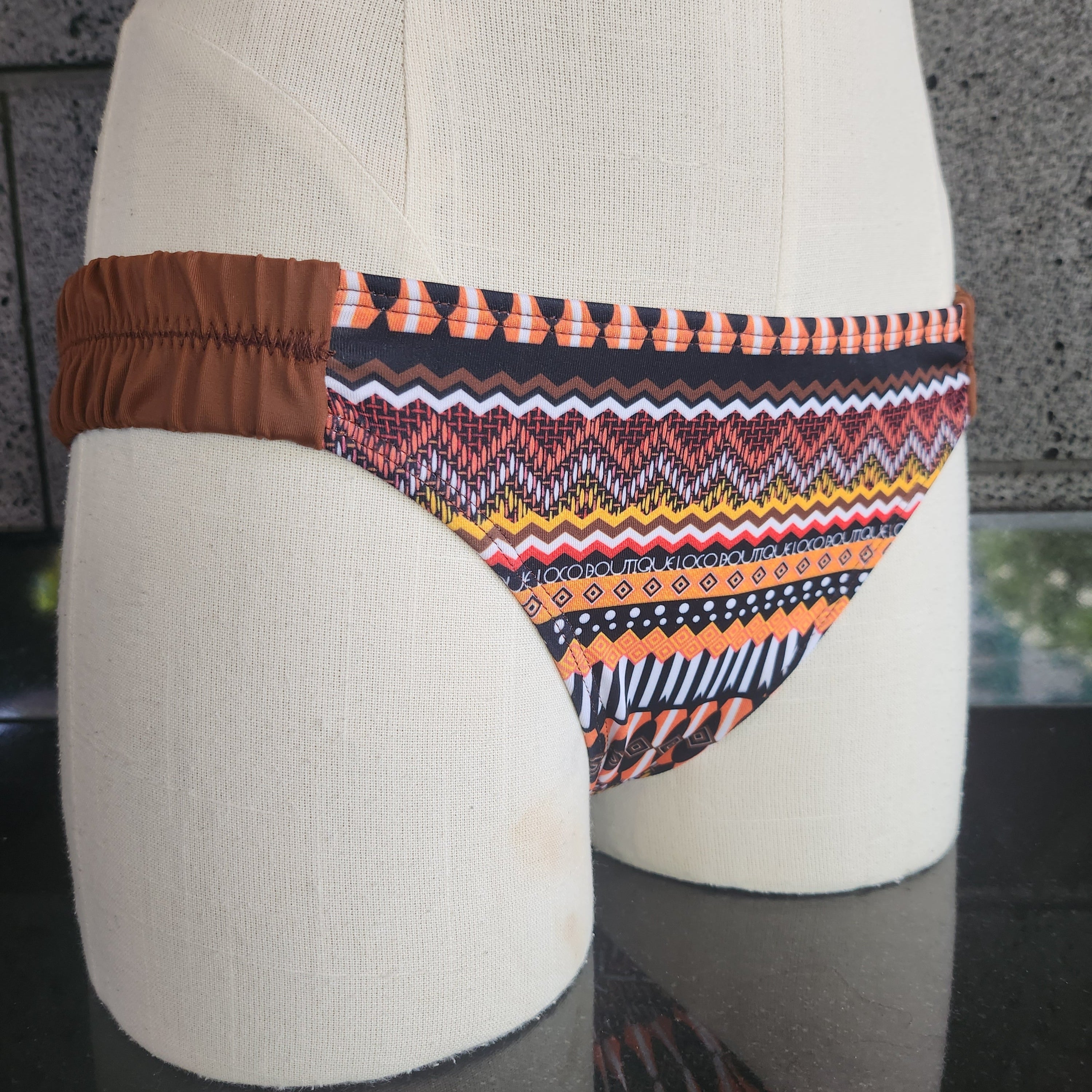 Colorful patterned bikini belt on a mannequin with a neutral background