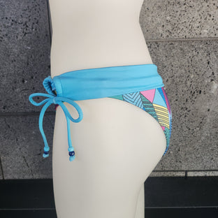 Colorful geometric-patterned bikini bottom on a mannequin against a neutral background