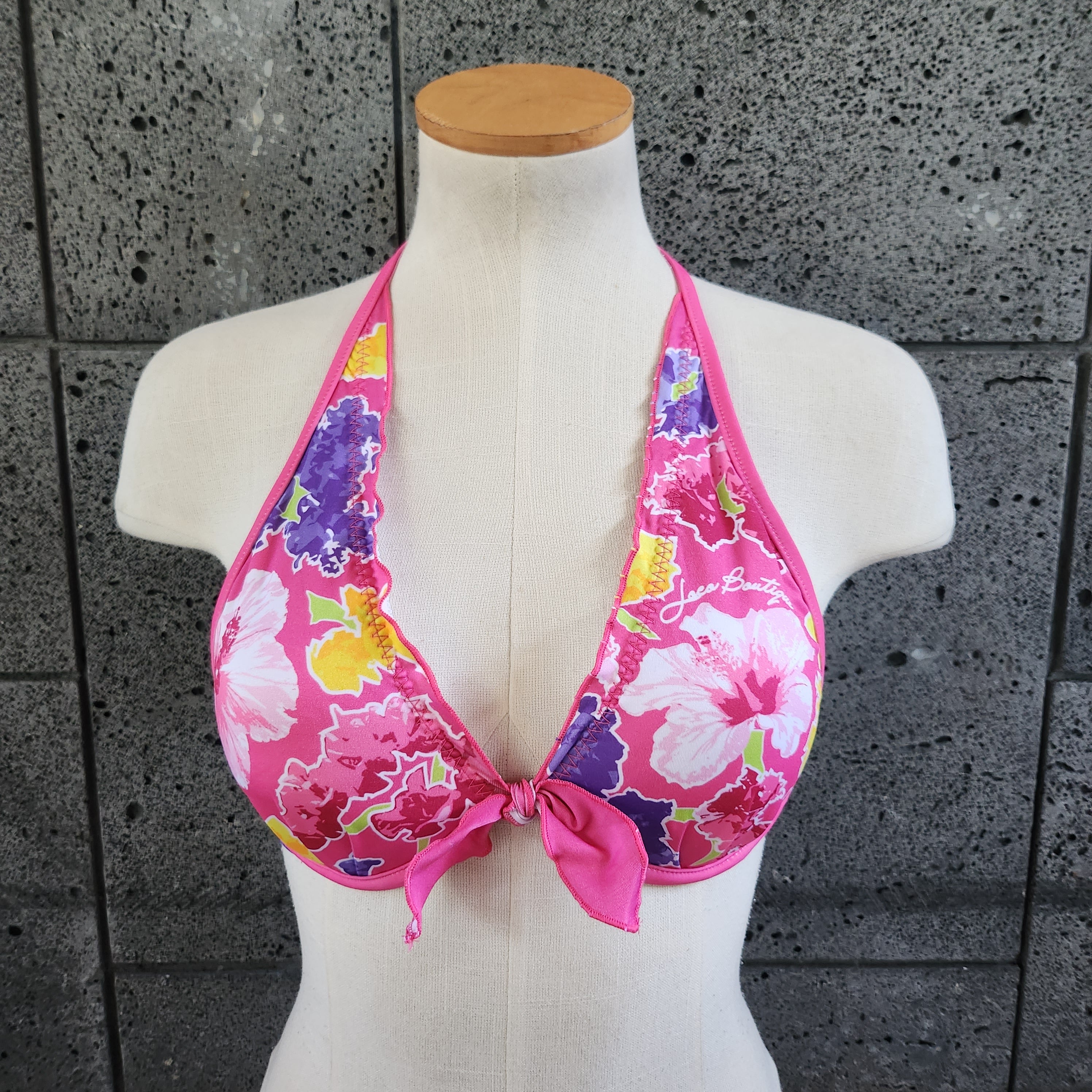 Floral bikini underwire top on a mannequin against a gray tiled wall