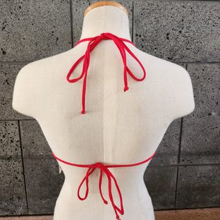 Colorful triangle top on a mannequin against a concrete wall.