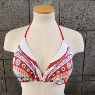 Colorful triangle top on a mannequin against a concrete wall.