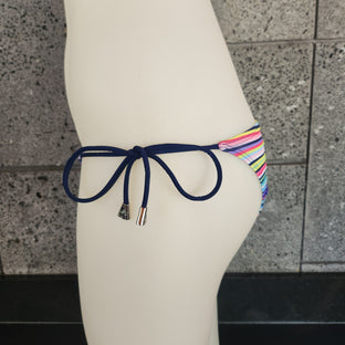 Colorful bikini bottom with cinched back on a mannequin against a tiled wall.