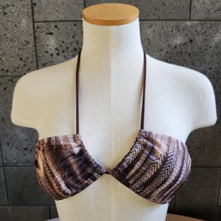 Mannequin wearing a brown patterned bandeau against a tiled wall.