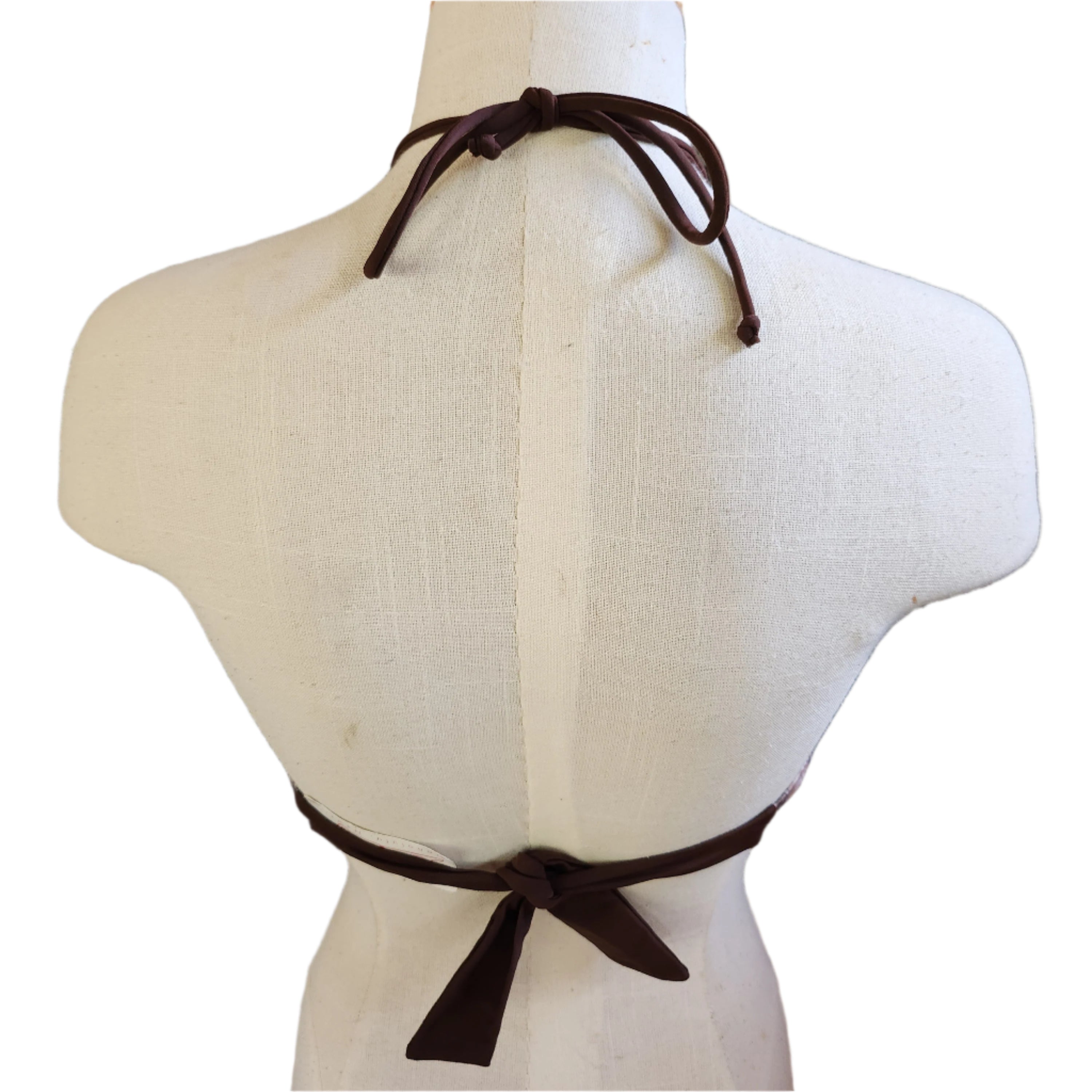 Mannequin wearing a brown patterned bandeau against a tiled wall.