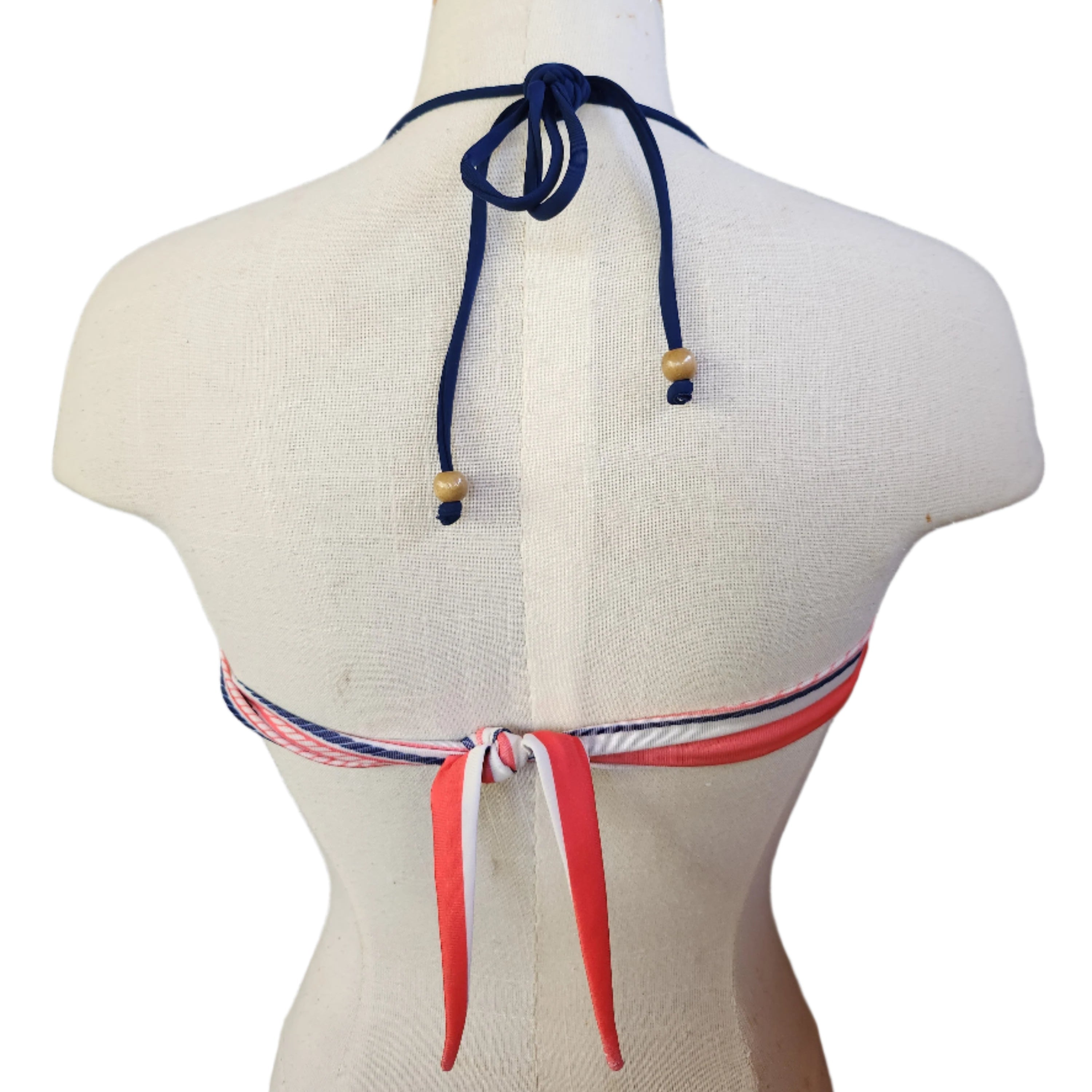 Navy blue bikini top with red and white stripes on a mannequin bust against a white background.