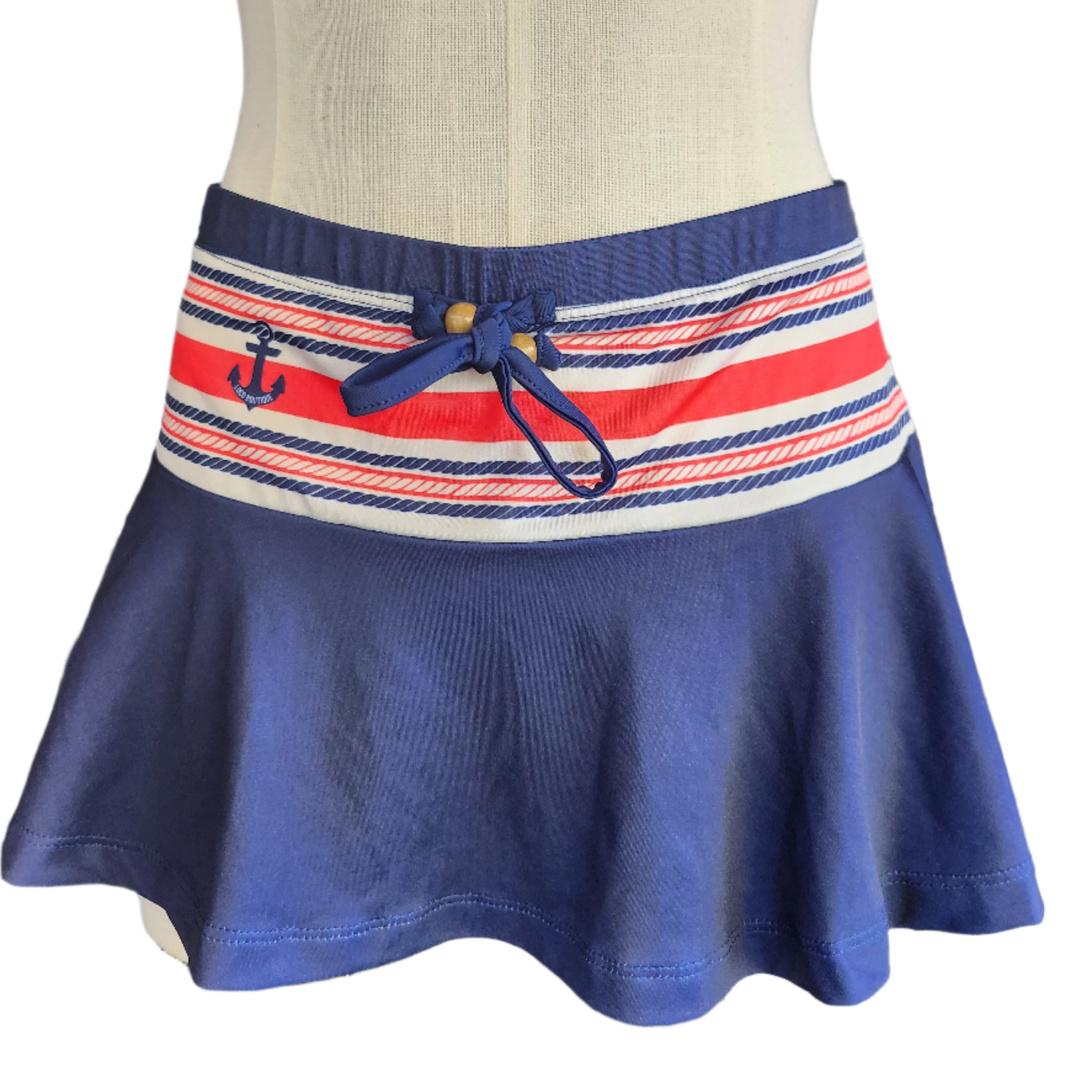 Navy skirt with a striped waistband featuring an anchor design on a mannequin.