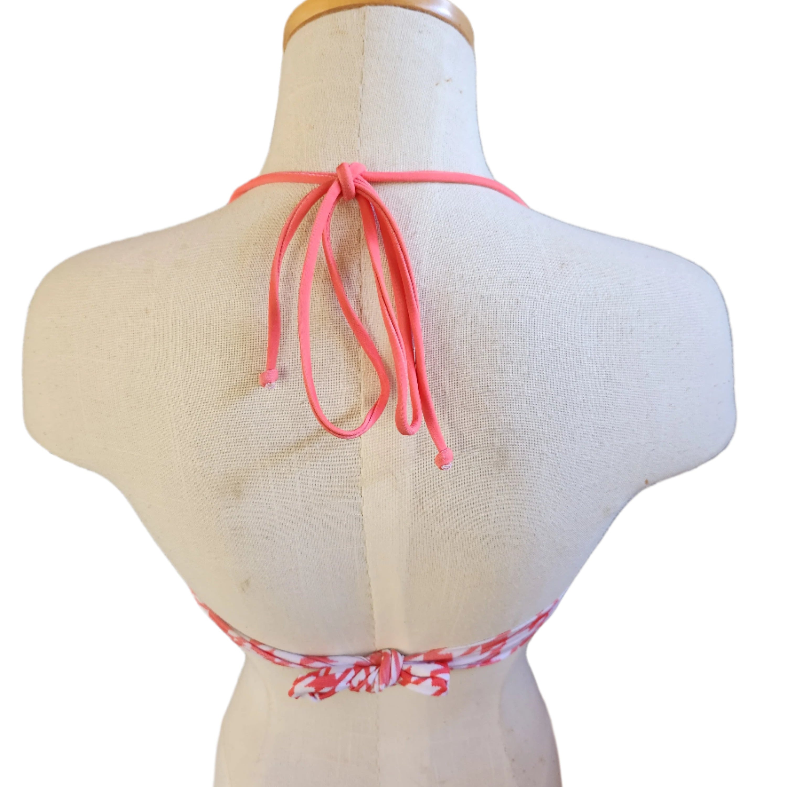 Black and white houndstooth patterned bikini top on a mannequin with a white background