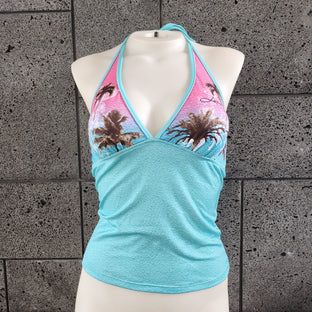 Mannequin wearing a halter tankini with palm tree design against a textured gray surface.
