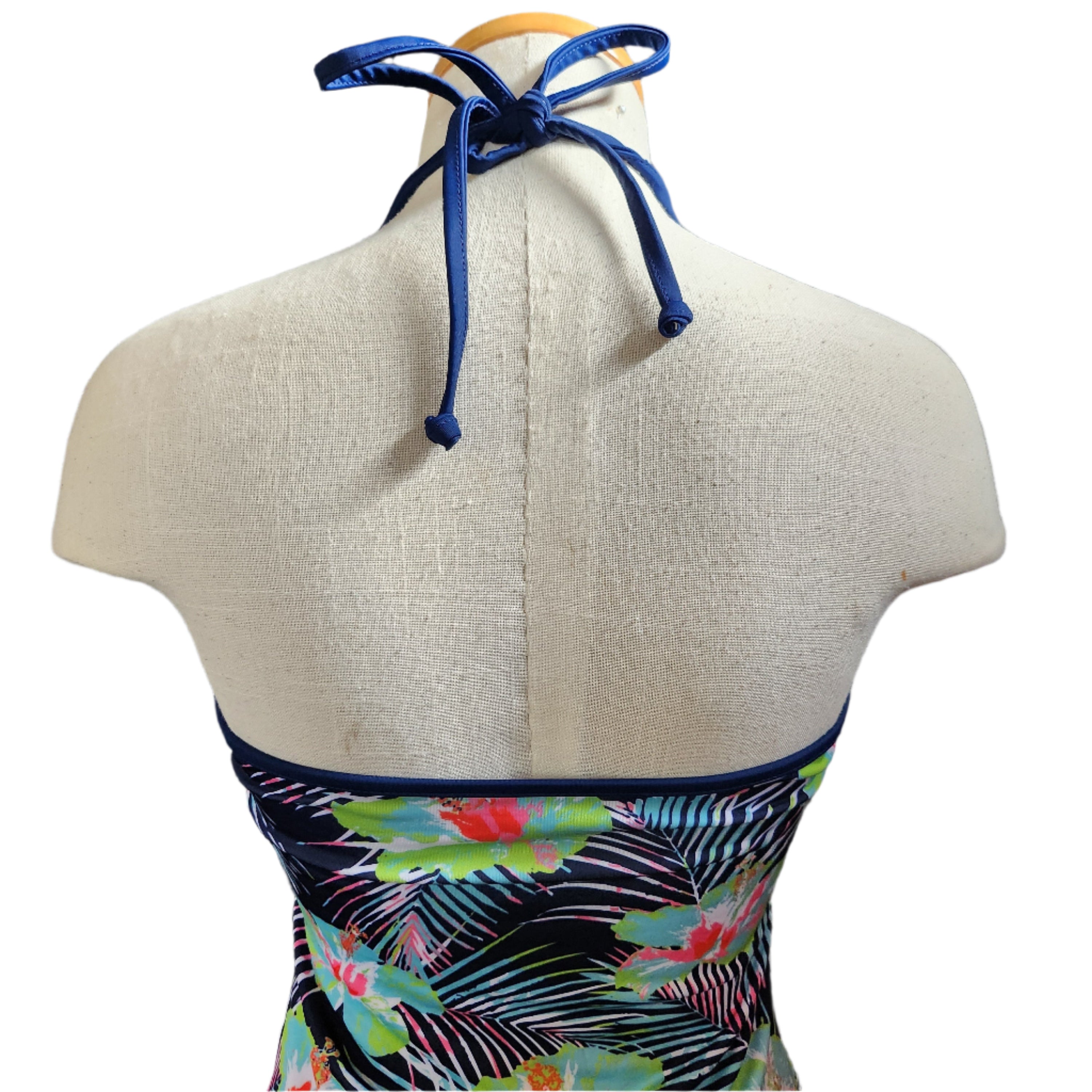 Colorful tankini with floral design on a mannequin against a white background
