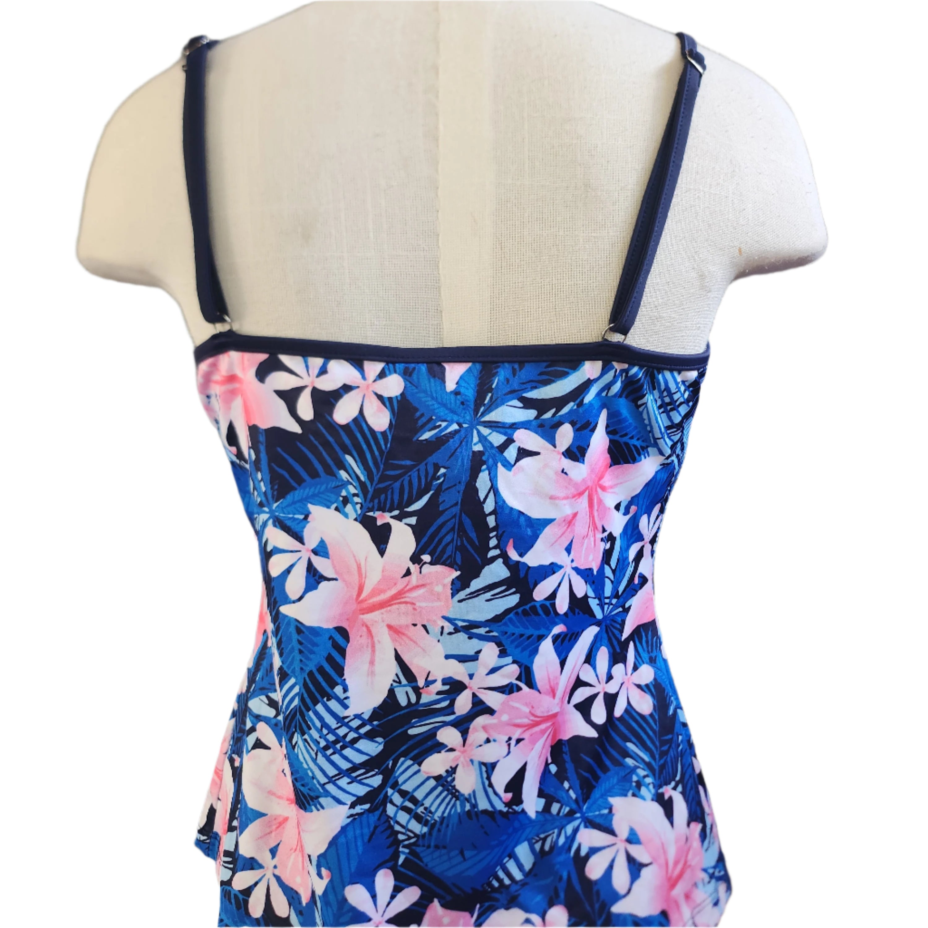 A woman wearing a blue and pink floral Casablanca Cami Tankini top with adjustable spaghetti straps.