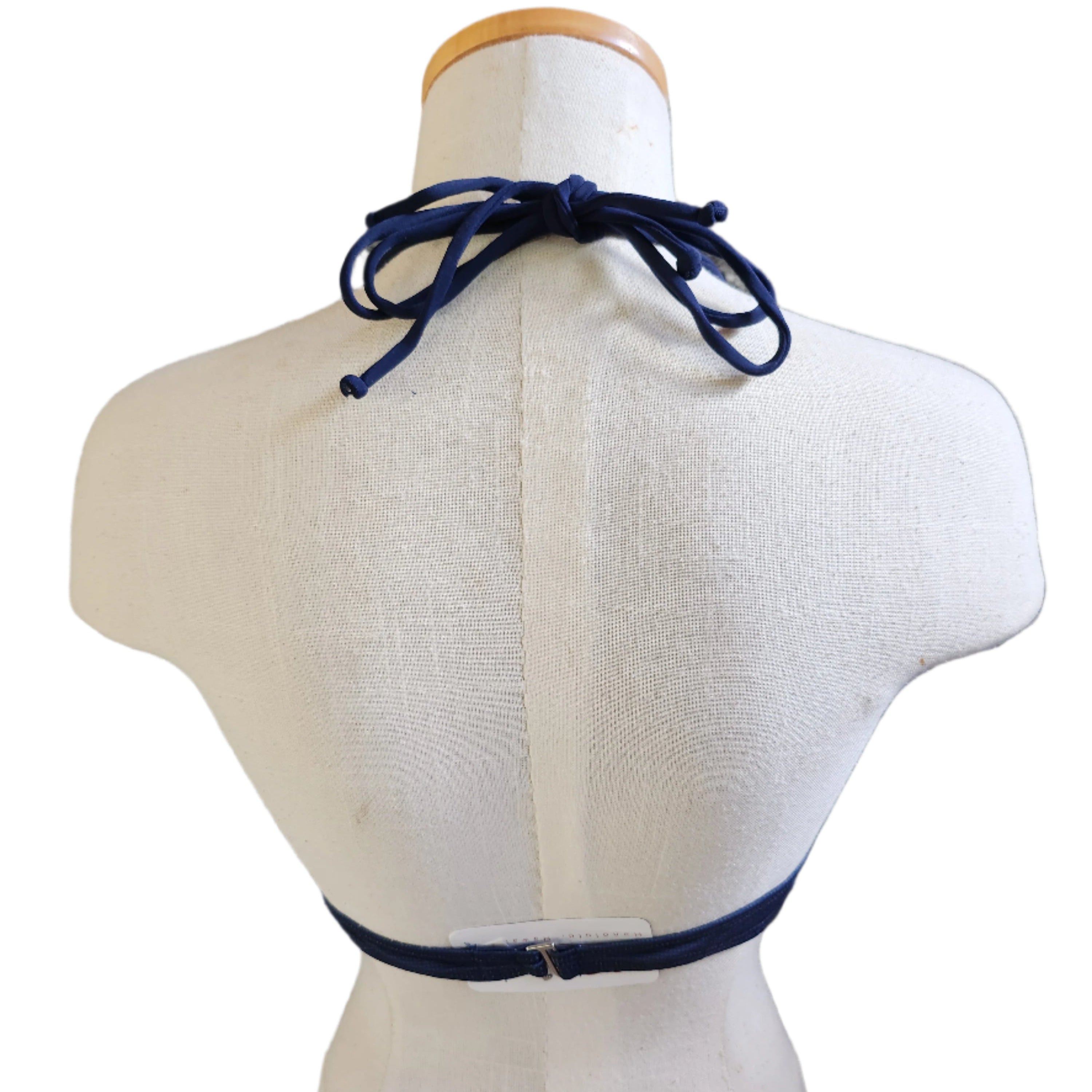 A vintage-style bikini top with a keyhole front and floral patterns, in shades of navy blue.