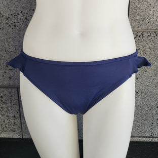 Navy blue bikini bottom on a mannequin against a gray tiled wall.