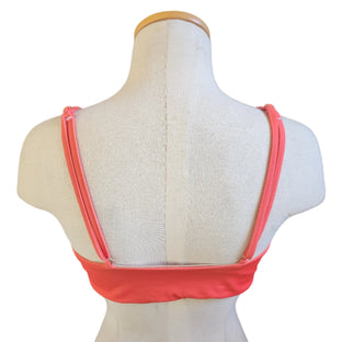 Blue bikini top on a mannequin against a tiled wall background