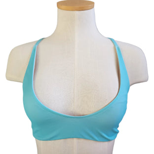 Blue bikini top on a mannequin against a tiled wall background