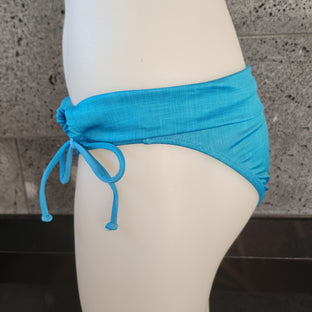 A swimwear garment with a folded over waistband and side gathered design, displayed on a mannequin.
