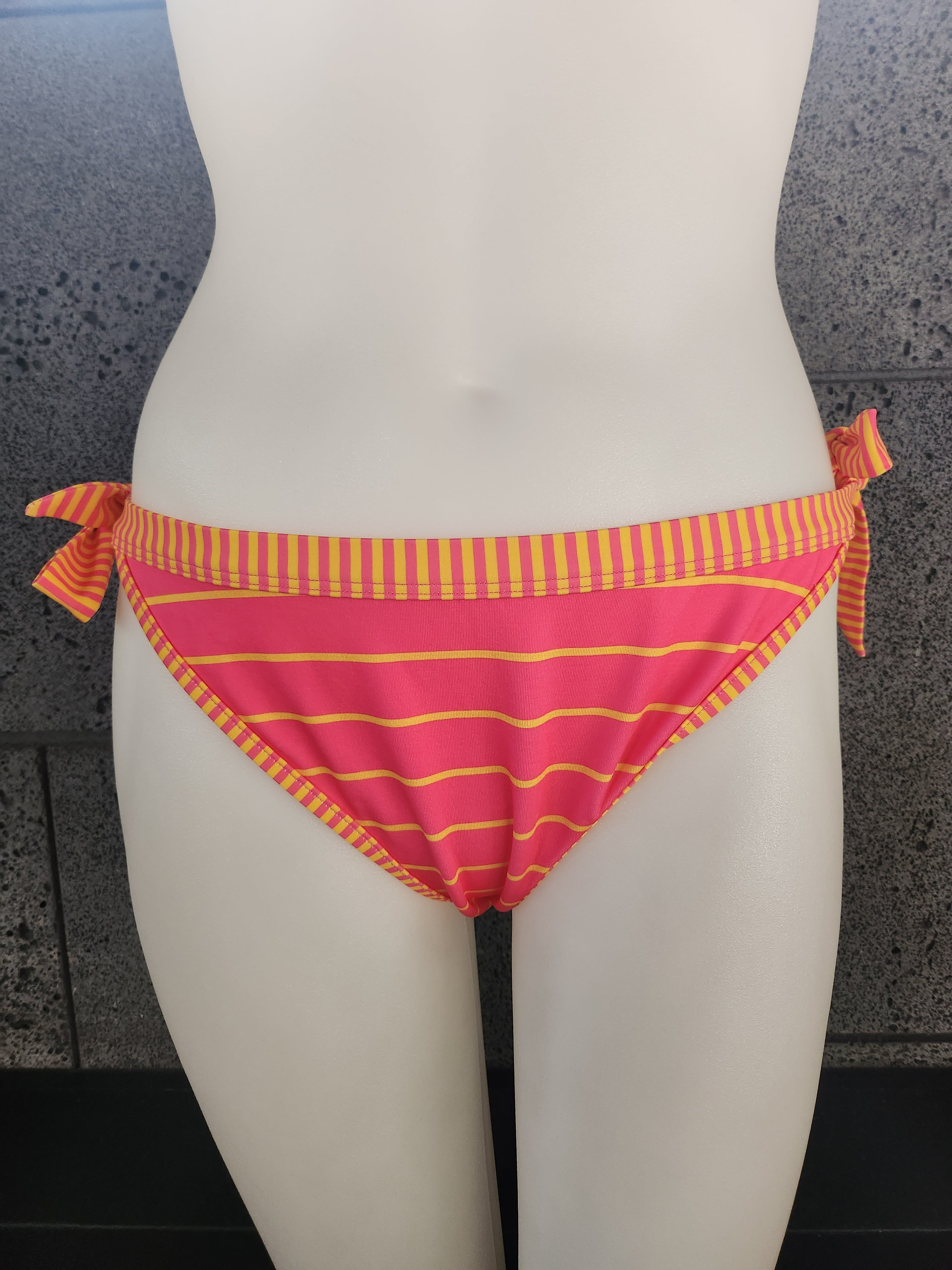 Black and red striped product with a pink heart on a mannequin against a gray background