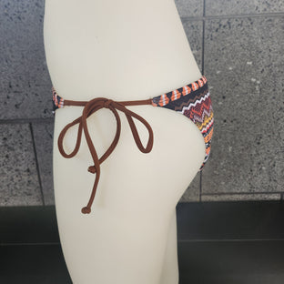 Decorative bikini bottom with a colorful pattern on a mannequin against a neutral background