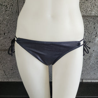 Purple patterned bikini top on a mannequin against a gray background