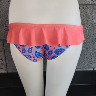 A model wearing a paisley skirted bikini bottom with a flirty ruffle waistband in teal blue.