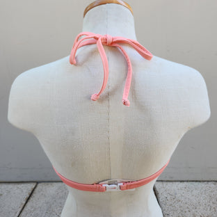 Navy blue bikini top on a mannequin against a gray tiled floor.