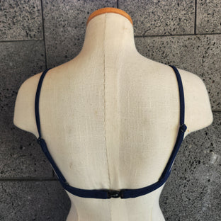 A brown underwire top on a mannequin bust, showcasing the front view with adjustable straps and a hook detail.