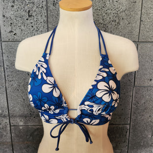 A woman wearing a blue floral bikini top with a keyhole front and banded chest.