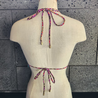 Colorful patterned bikini top on a mannequin with a white background.
