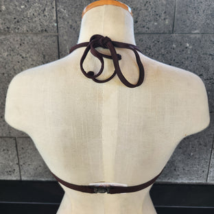 Navy blue bikini top on a mannequin against a gray tiled floor.