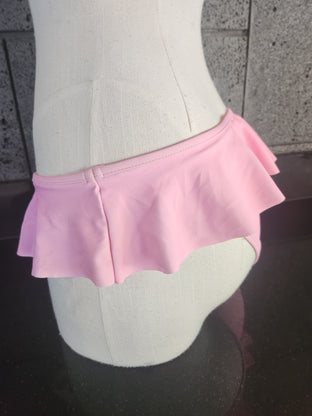 A pair of pink ruffled skirted bottoms displayed on a mannequin.