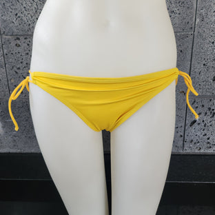 Purple patterned bikini top on a mannequin against a gray background