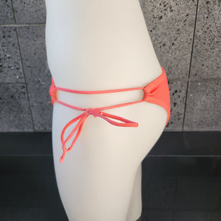 Purple patterned bikini top on a mannequin against a gray background